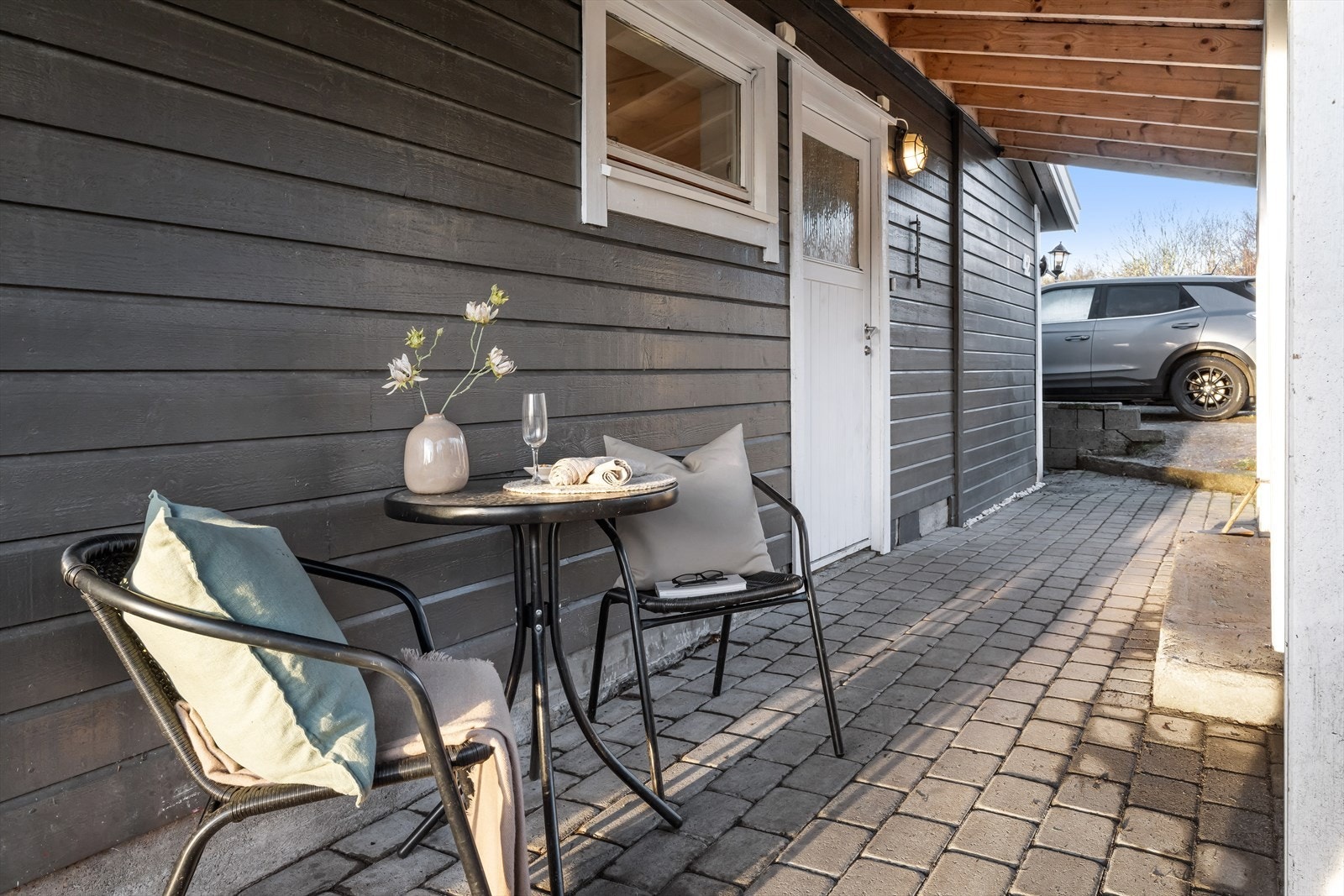 Inngangspartiet er overbygget og har belegningstein langs husveggen. Galleribilde