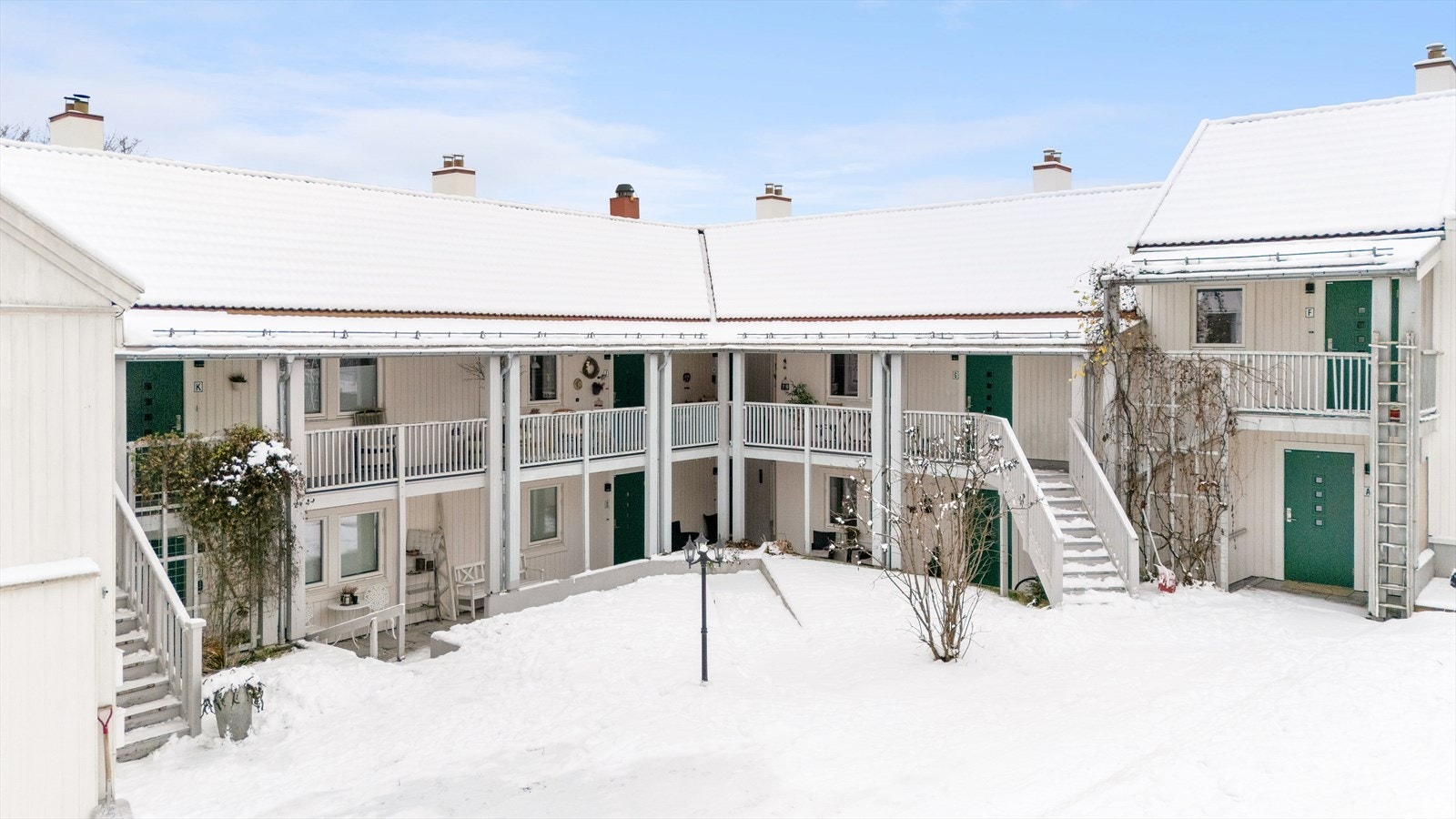 Fasade indre bakgård og inngangspartiet innerst i hjørnet - Pent opparbeidet med stier, plen og beplantning Galleribilde