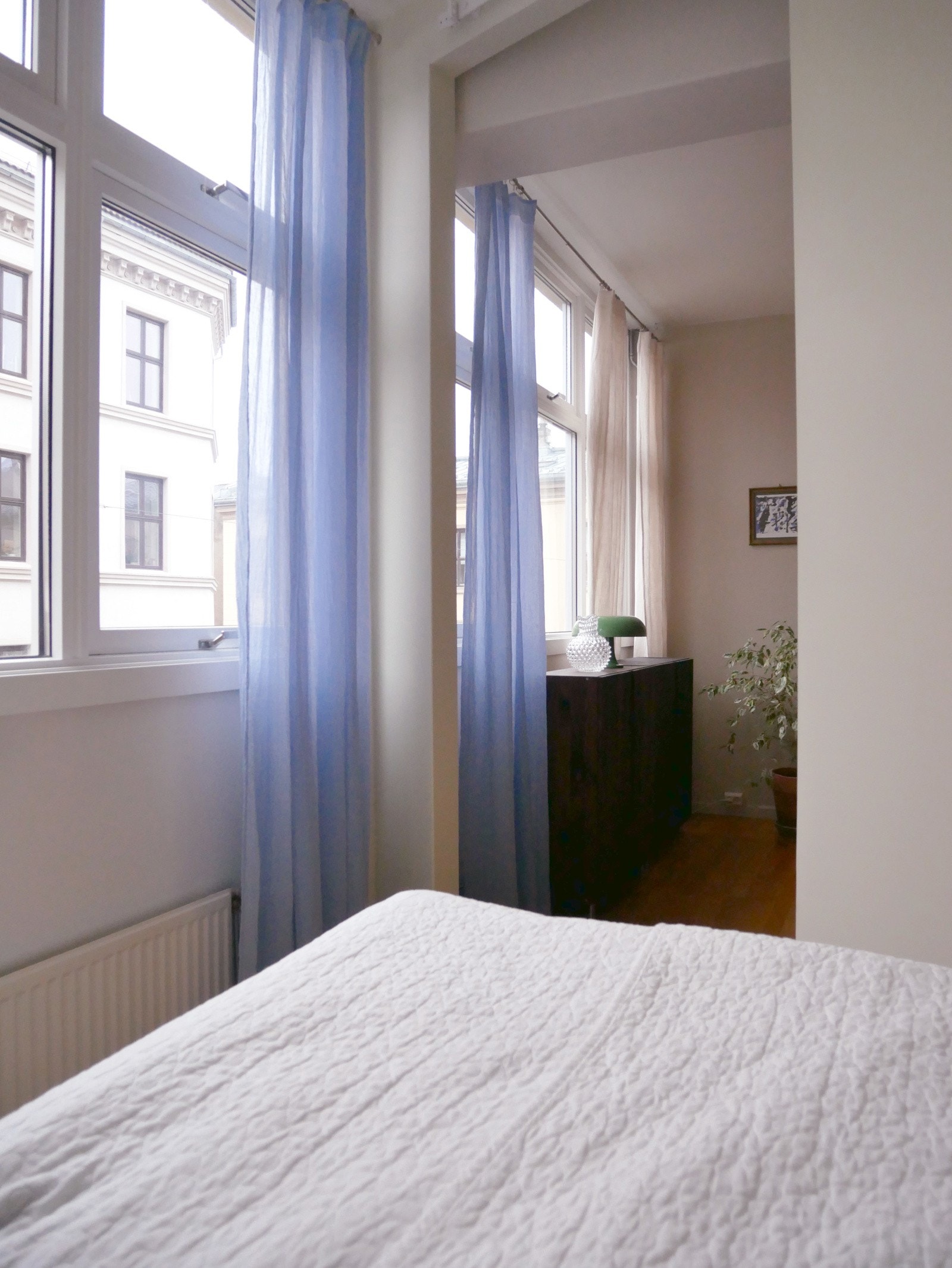 Døråpningen inn fra stue til soverom er høy og plassert ut mot fasaden, slik at man kan nyte full vindusrekke fra begge rom når skyvedøren er åpen. Galleribilde