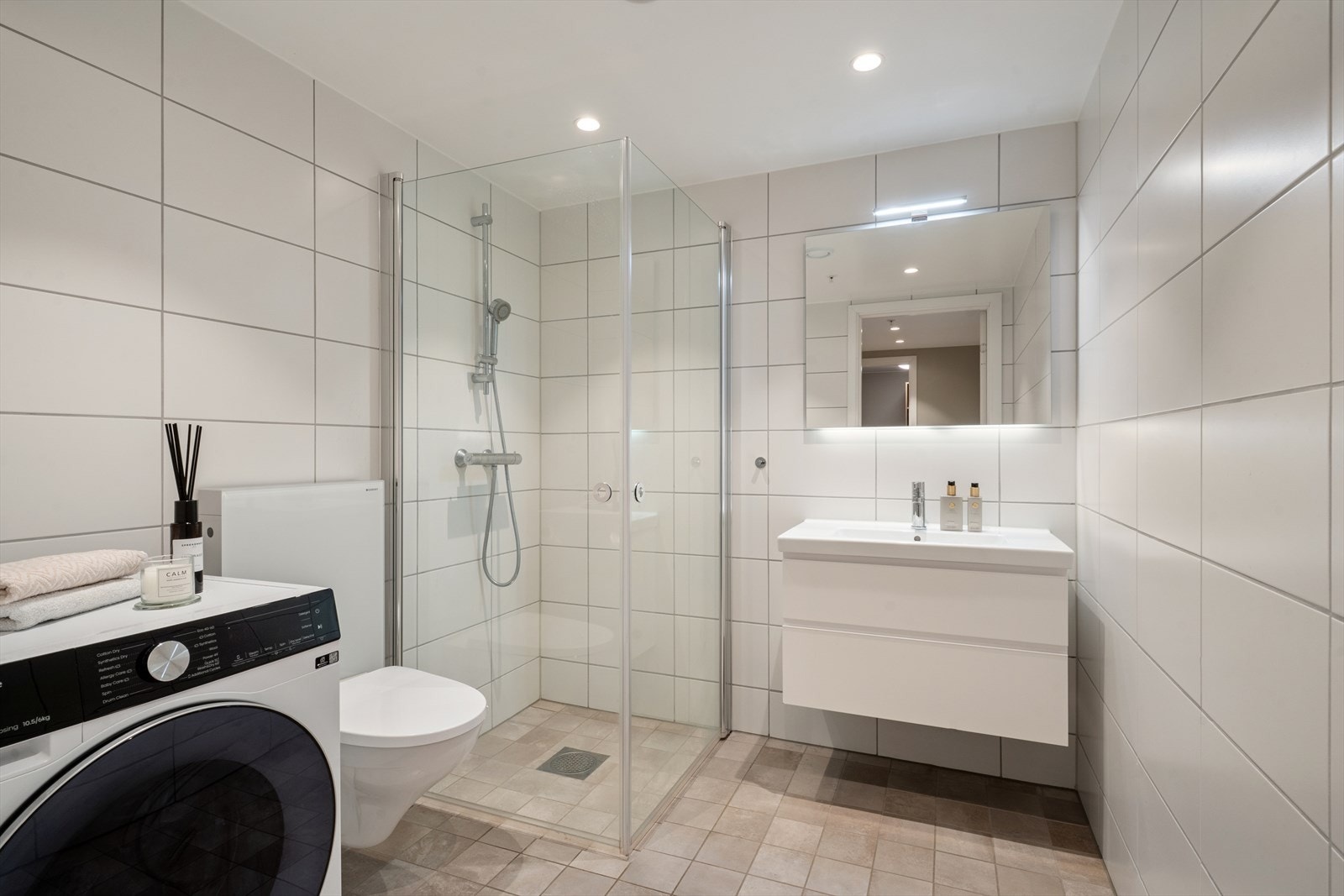 Videre har leiligheten et flislagt bad med opplegg for vaskemaskin. Galleribilde