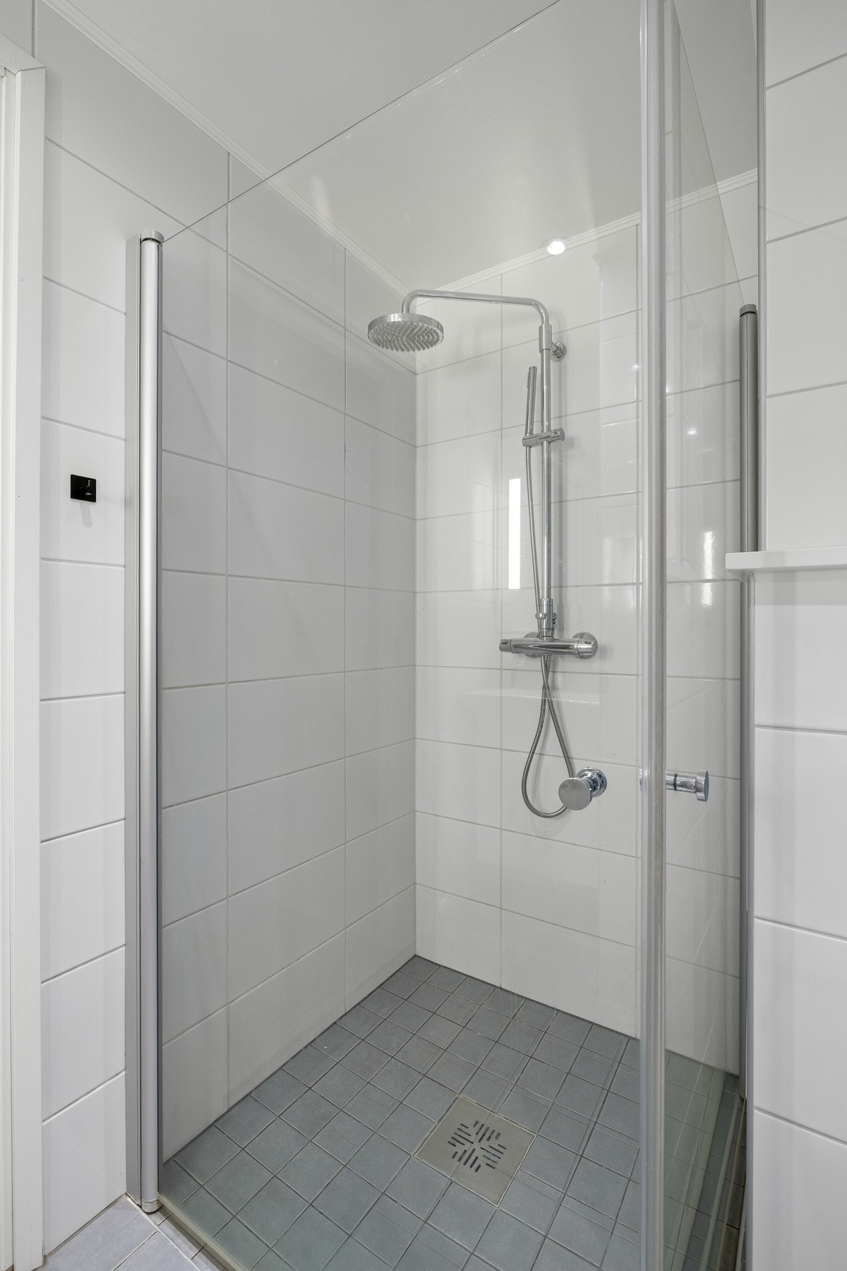 I dusjen er det lagt matchende fliser av mindre dimensjon enn øvrige gulvfliser og dusjvegger med glassdører av herdet glass. Galleribilde