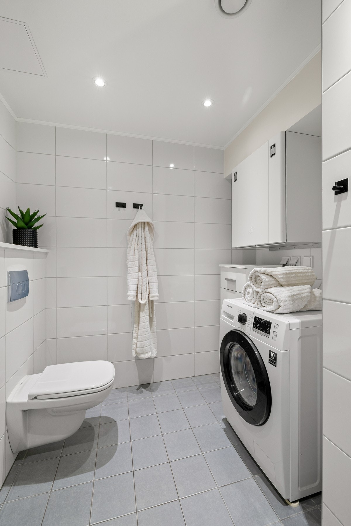 Vaskemaskin og tørketrommel som "side-by-sideløsning" m/skjermvegg som danner en fin nisje. Galleribilde