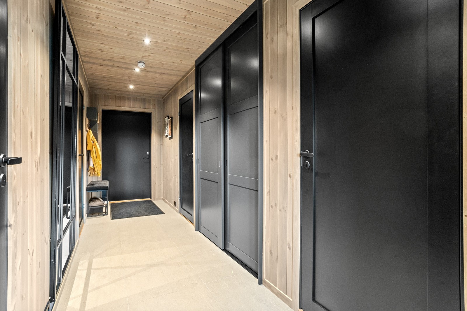 Her finner du en stor, plassbygd skyvedørsgarderobe som gir rikelig med oppbevaringsplass for yttertøy og sko. Galleribilde