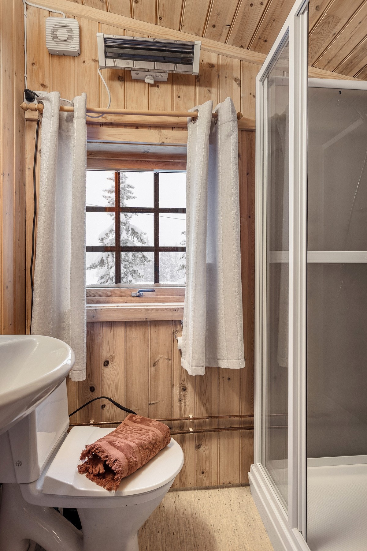 Badet i annekset er praktisk utformet med vegger i panel/tømmer og panel i himling, som gir et helhetlig og hyggelig uttrykk i tråd med anneksets stil. Galleribilde