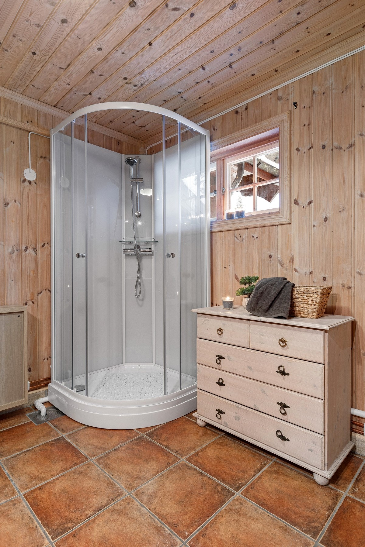 Praktisk bad/vaskerom har vegger og himling med panel. Gulvet er flislagt og har elektriske varmekabler. Galleribilde