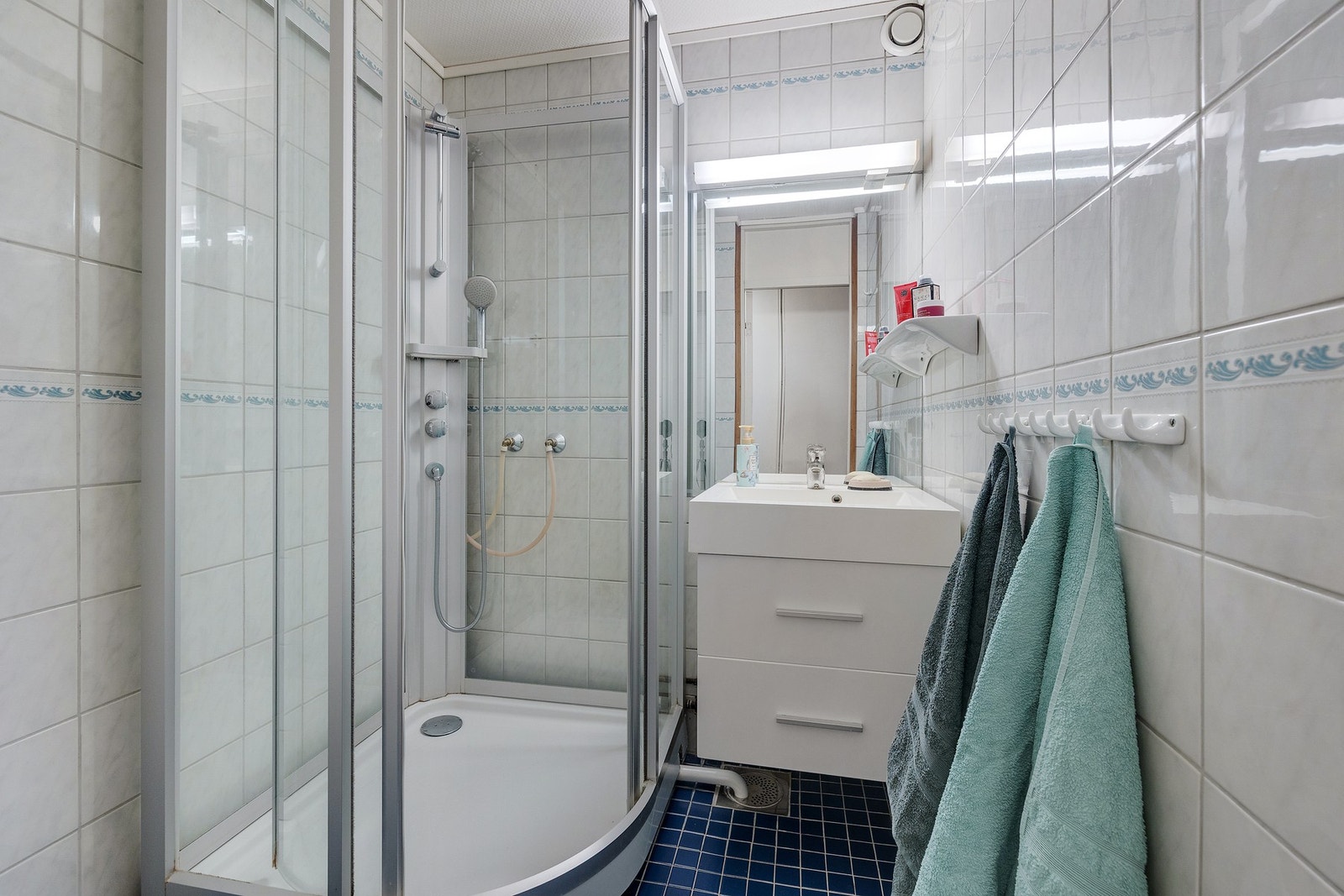 Flislagt bad med gulvvarme, dusjkabinett og servant med underskap Galleribilde