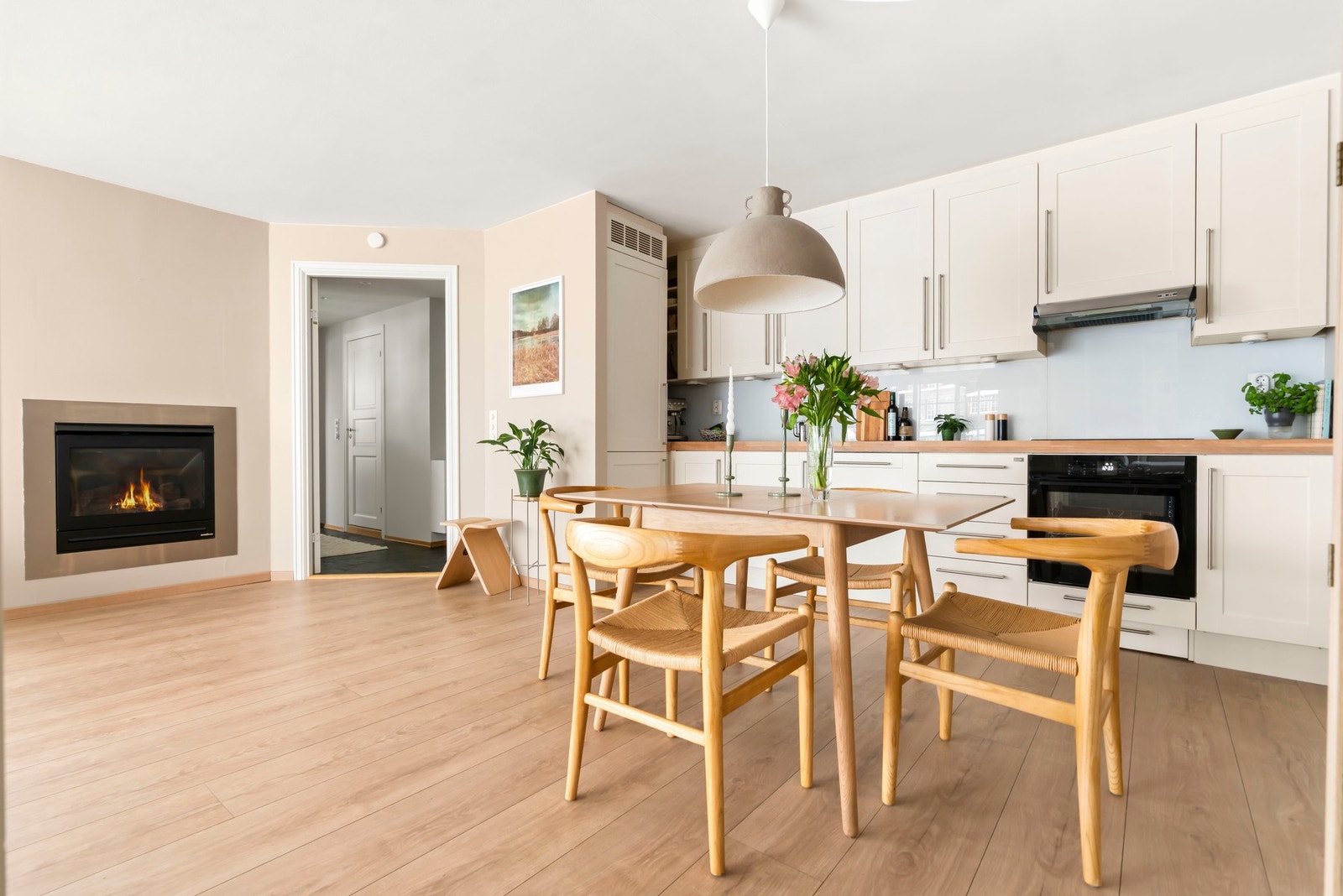 Kjøkkeninnredningen består av hvite en-speils fronter og stålhåndtak, overskap med benkebelysning og plate på vegg. Heltre benkeplate med underlimt stålkum og ett-greps armatur i krom Galleribilde