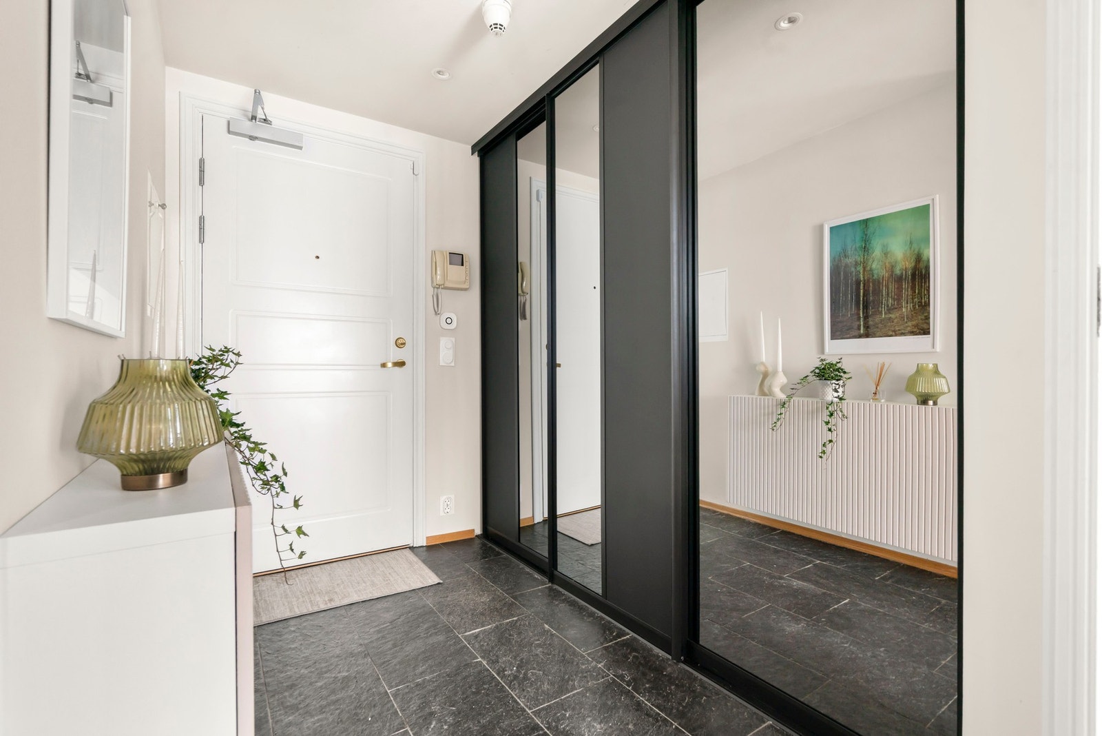 Hyggelig og imøtekommende entré med flere praktiske oppbevaringsmuligheter i stor skyvedørsgarderobe og vegghengt hylle Galleribilde