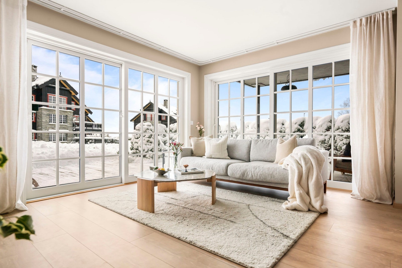 Lyst og luftig oppholdsrom med to store skyvedører som strekker seg fra gulv til tak og som gir stuen god tilgang på naturlig lys og fantastisk utsyn Galleribilde