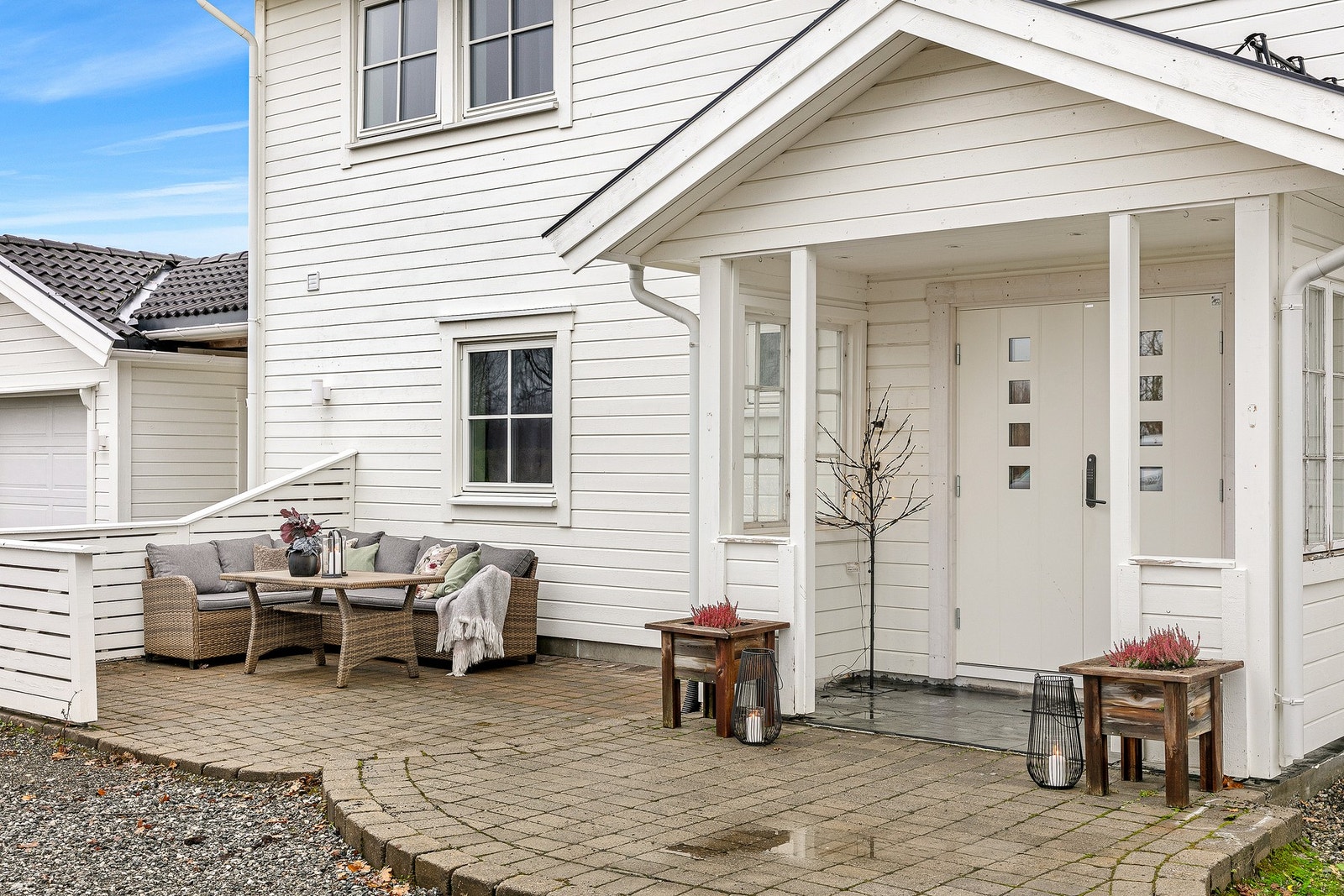 Inngangspartiet sett i dagslys med hyggelig sitteplass. Galleribilde