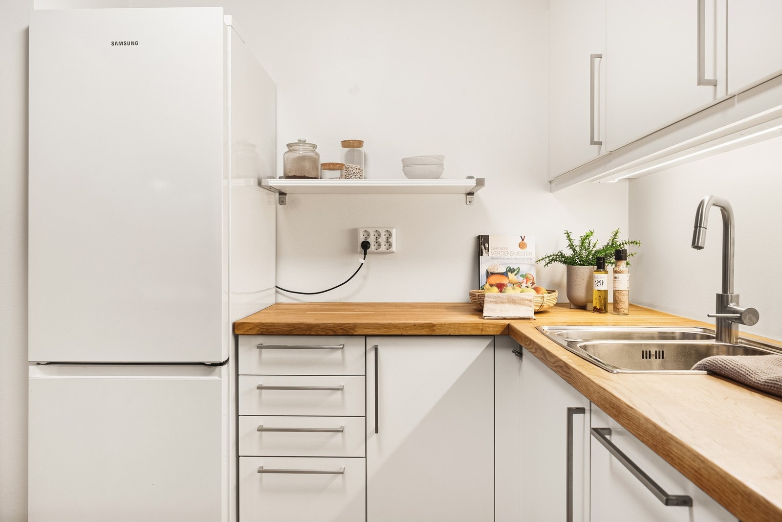 Integrerte hvitevarer består av stekeovn, platetopp, oppvaskmaskin og ventilator. Det er plass/opplegg for kjøleskap. Galleribilde