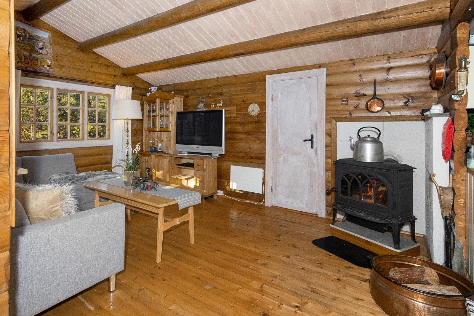 Koselig stue med vedovn som gir en lun og behagelig varme på kjølige dager Galleribilde