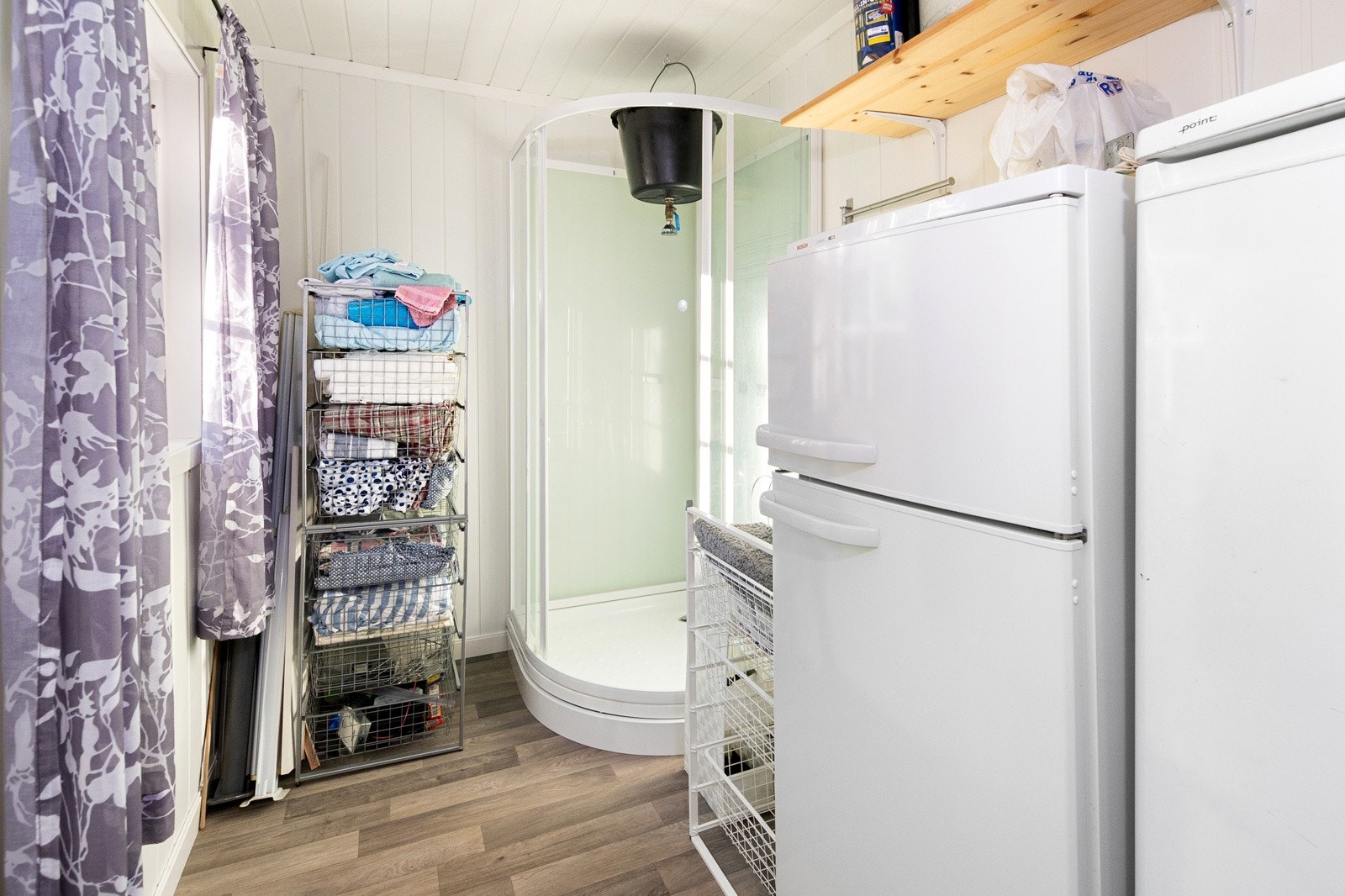 Rom med dusj i tilbygget. Her er det også god plass for f.eks. ekstra kjøleskap. Megler gjør oppmerksom på at rommet er vist som stue/soverom på tegninger mottatt fra kommunen. Det er usikkert om dette er søkt bruksendret hos kommunen. Galleribilde