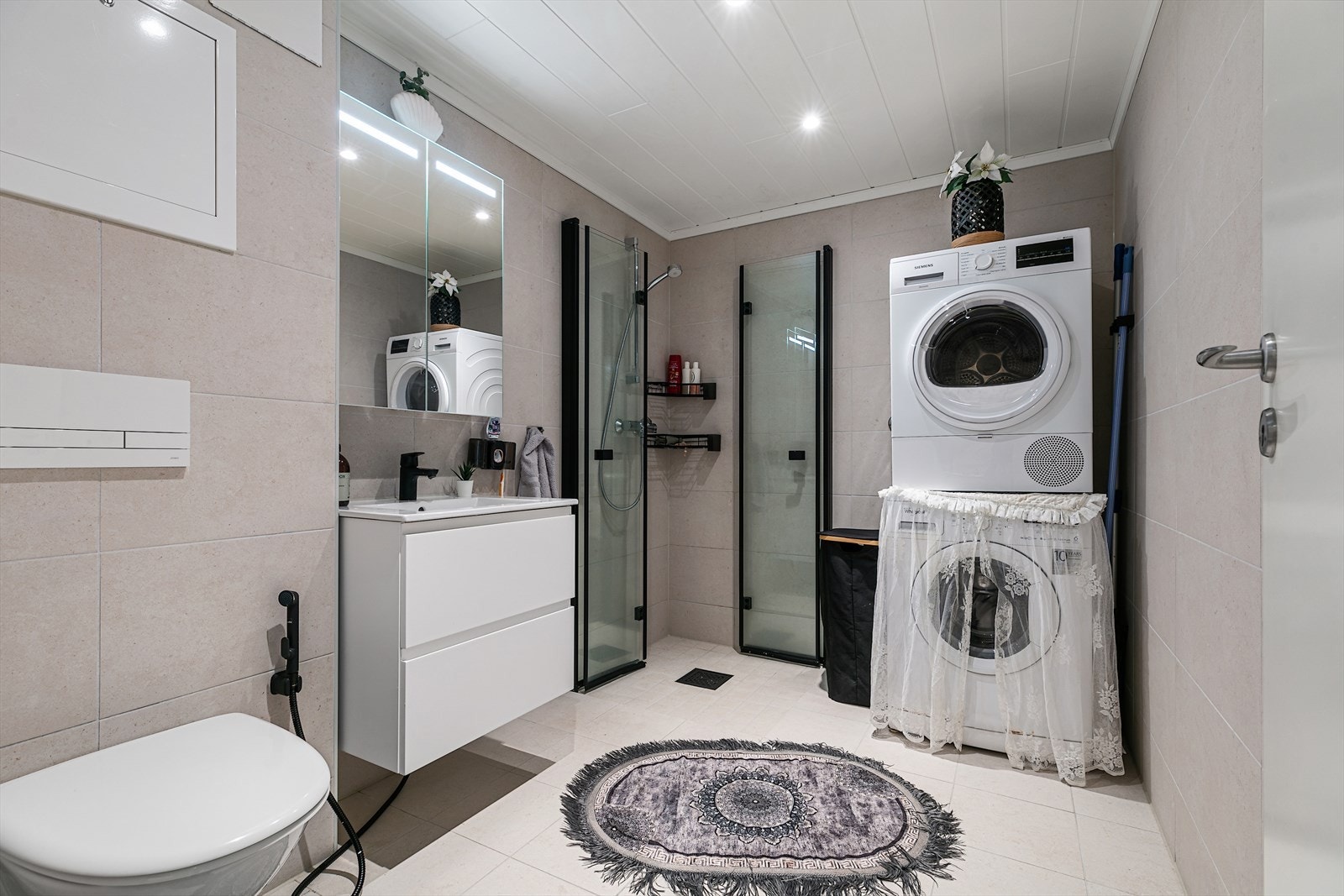 Baderomsinnredningen er lys med heldekkende nedfelt servant og rom for oppbevaring i skuffeseksjon og speilskap med belysning. Galleribilde