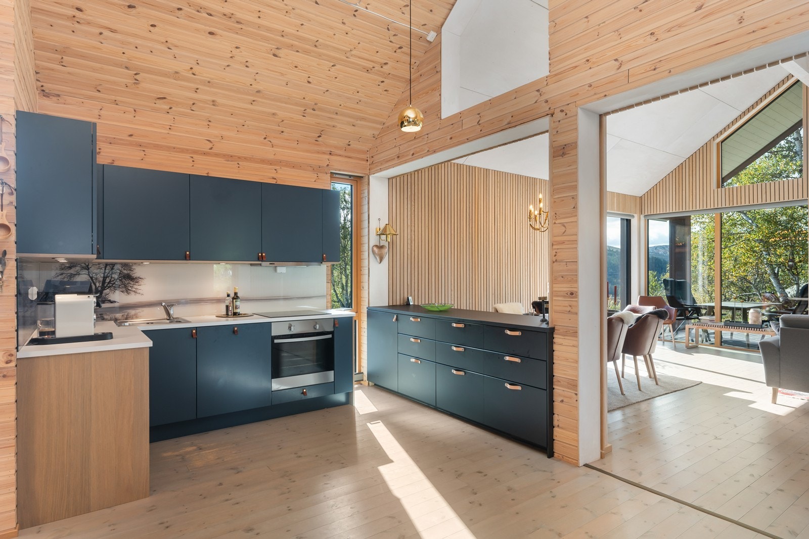 Kjøkkeninnredningen har en behagelig og fin blåfarge som gir en elegant kontrast til treverket i vegger og tak. Galleribilde