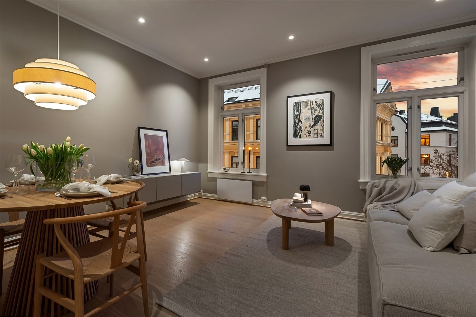 Stuen på kveldstid byr på en lun og behagelig atmosfære, med spotbelysning og utsyn mot kveldshimmelen. Galleribilde