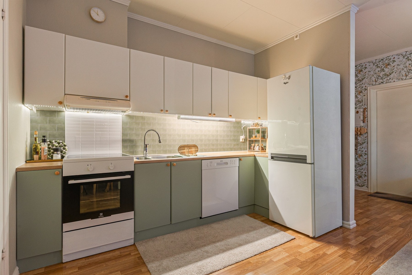 Kjøkkenet holder et tidløst preg med sine slette lyse fronter Galleribilde