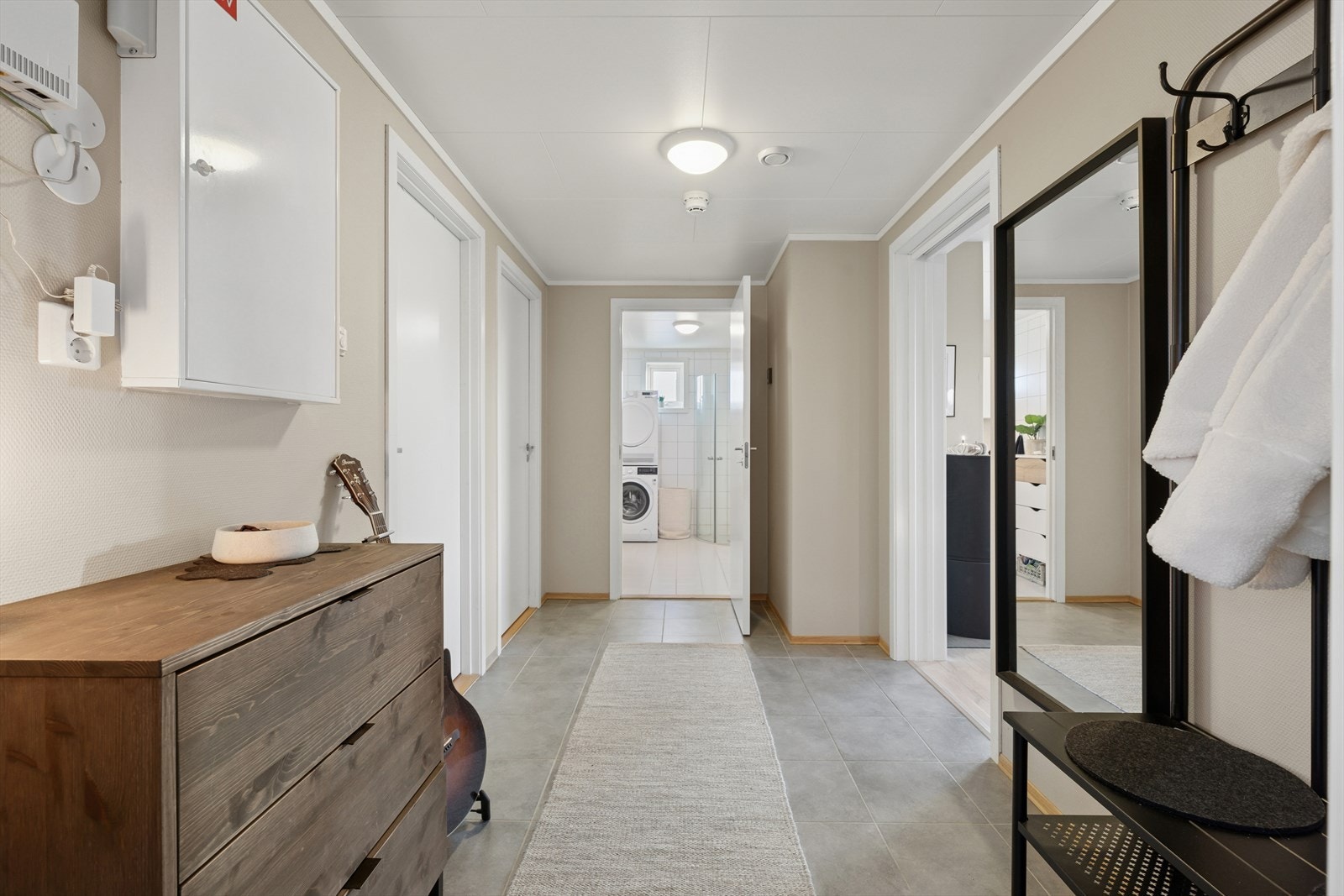 Man ønskes velkommen inn i en lys og romslig entré som er praktisk innredet med flislagt gulv og hvor man har god plass til å henge fra seg yttertøy og sko. Her får man umiddelbart et godt førsteinntrykk av boligen. Galleribilde