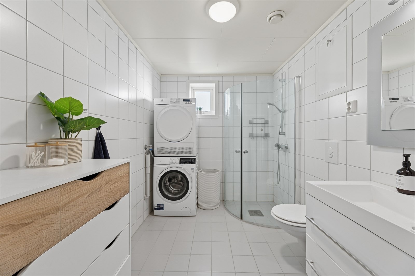 Badet er tidløst innredet med grå fliser på gulvet og hvite fliser på vegg. I gulvet har man også varmekabler for ekstra komfort. Galleribilde