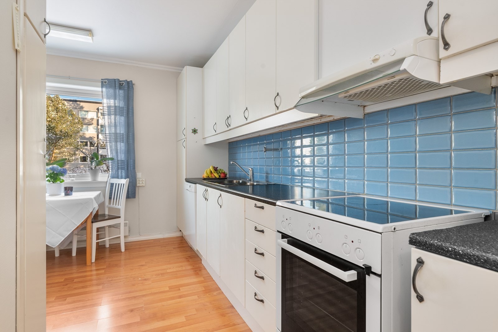 Kjøkkenet har en lys innredning med slette fronter og laminert benkeplate med nedfelt oppvaskkum. Galleribilde