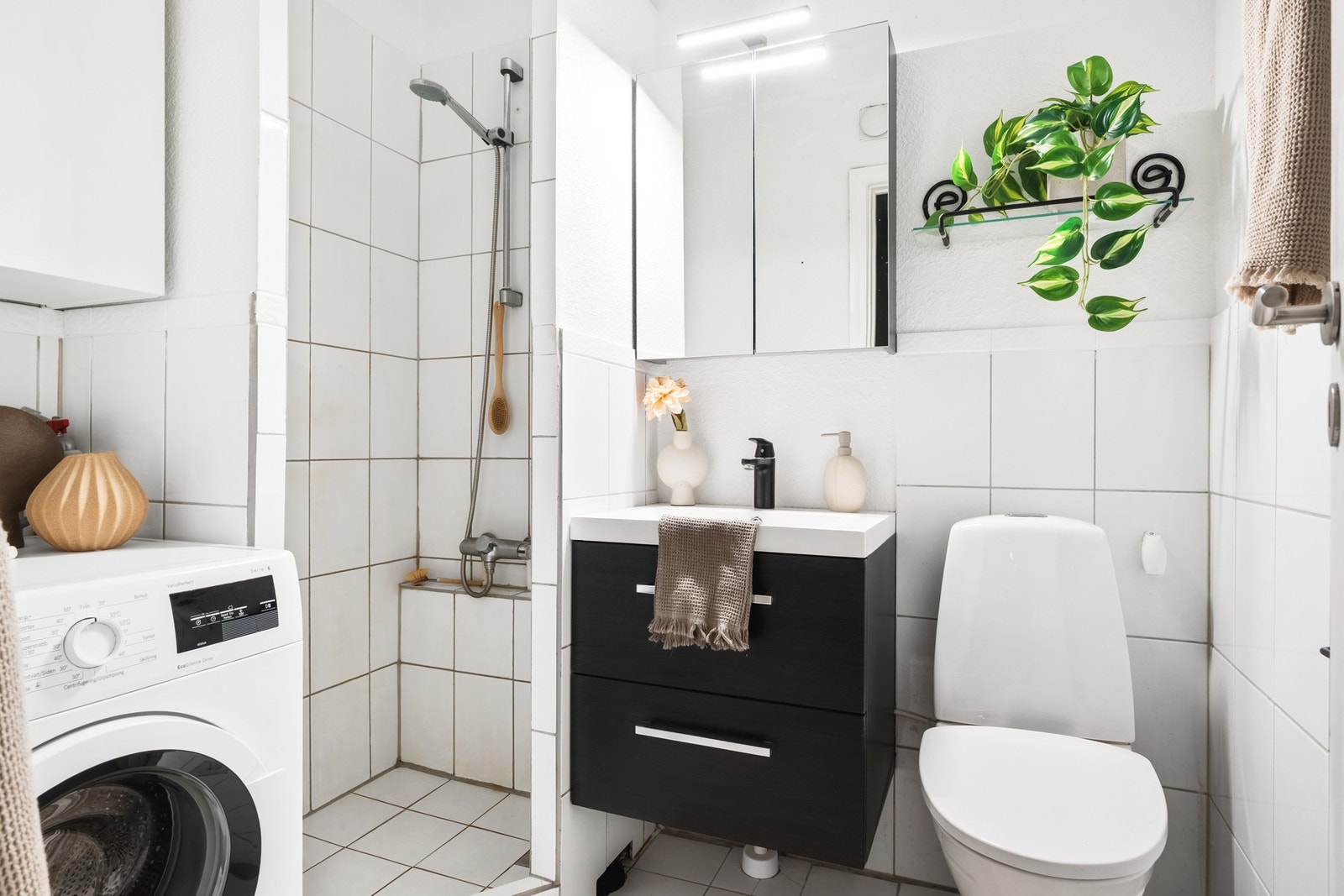 Badet er godt utnyttet og har dusjnisje, opplegg for vaskemaskin, servant med oppbevaring og toalett. Galleribilde