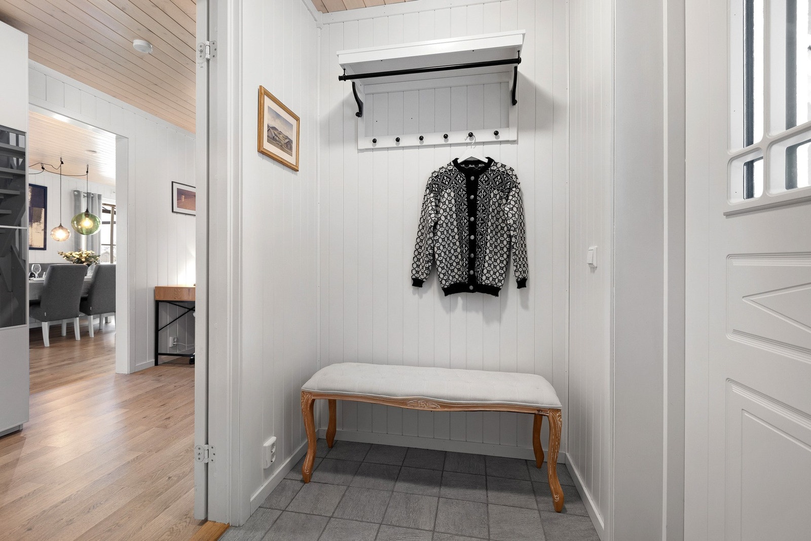 Flislagt vindfang med varmekabler, dør inn til gangen som også har et garderobeskap Galleribilde
