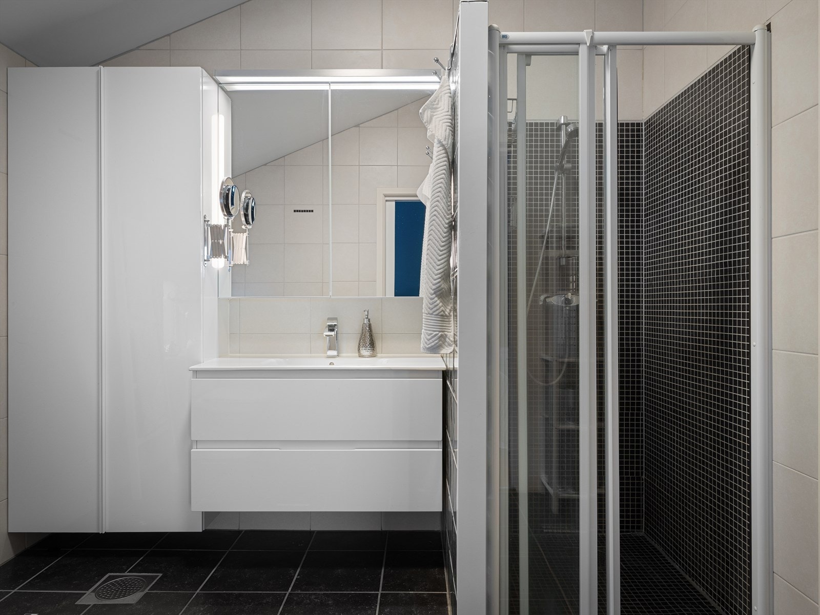 Skyvedør i dusjen. Ekstra skapplass og oppbevaring på badet med veggskap, seksjon og speilskap. Et godt baderom i tidløs utførelse. Galleribilde