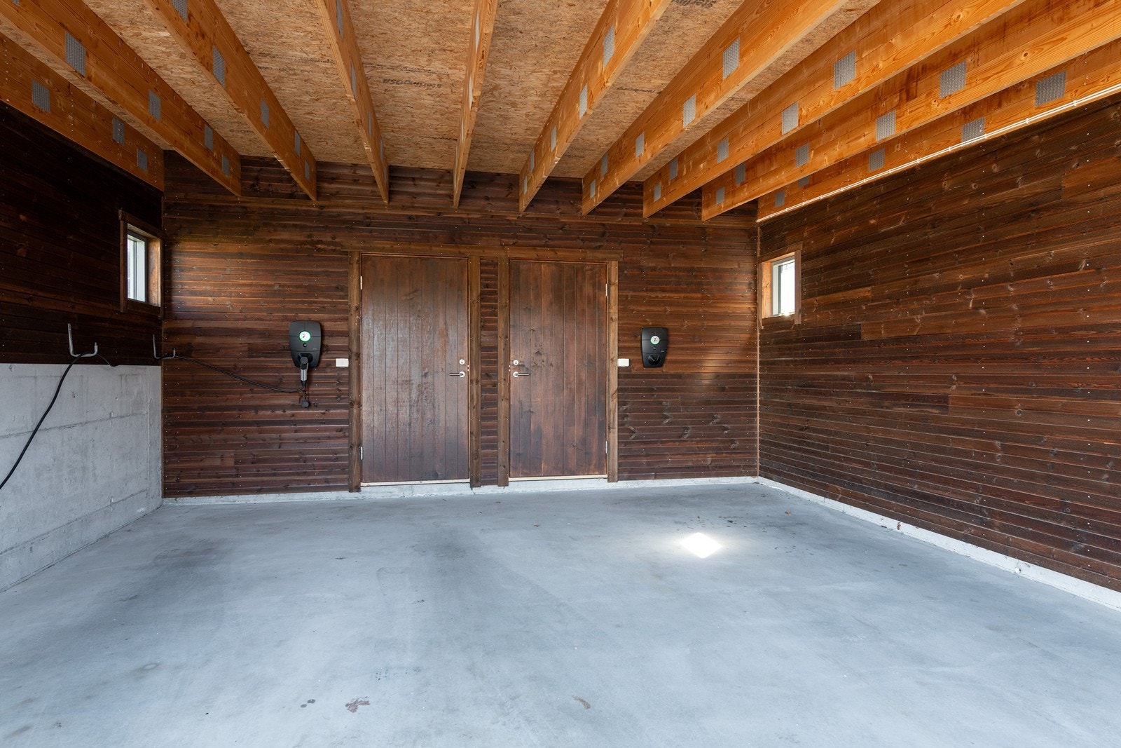 Det medfølger en parkeringsplass i delt carport (mot høyre i bilde) med egen lader fra Zaptech og tilliggende sportsbod Galleribilde