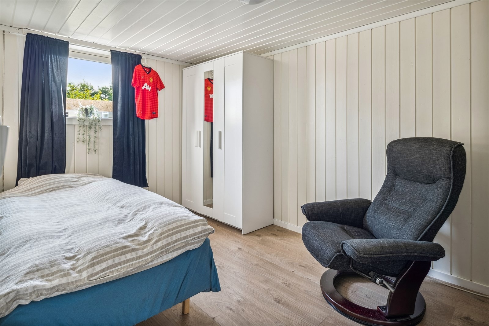 Det andre soverommet i leilighet 2 ligger i kjelleretasjen. Soverommet har god standard med laminat på gulv, lyse panelplater på veggene og er utstyrt med garderobeskap. Galleribilde