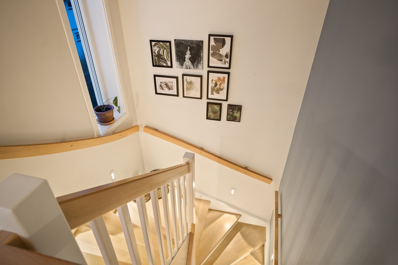 Effektfull belysning fremhever trappen der både trinn, håndløpere og rekkverk er i heltre. Galleribilde