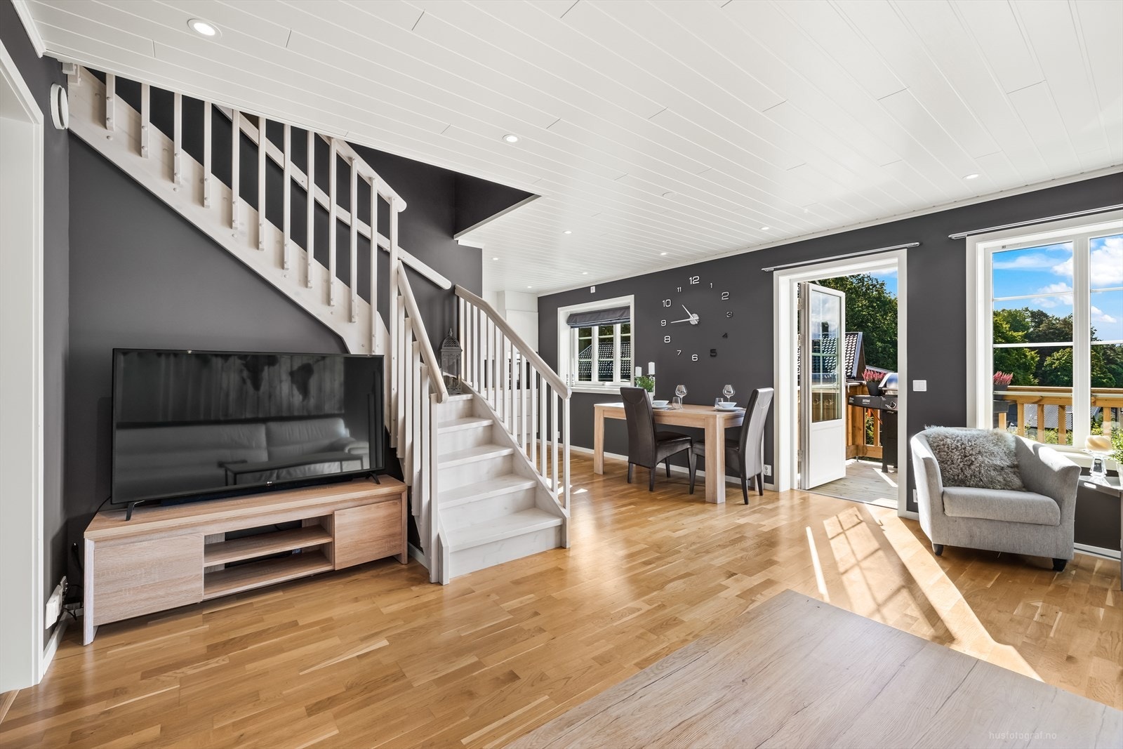 Rommet har et elegant samspill mellom mørke og lyse kontraster, der mørkegrå vegger gir et stilrent bakteppe til den hvite himlingen og 3-stavs parkett på gulv. Galleribilde