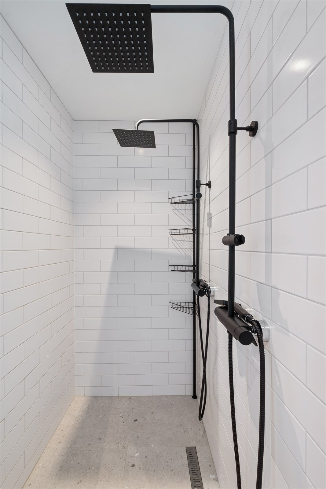 Her er det også en flislagt dusjnisje med glassdører og to dusjhoder. Galleribilde