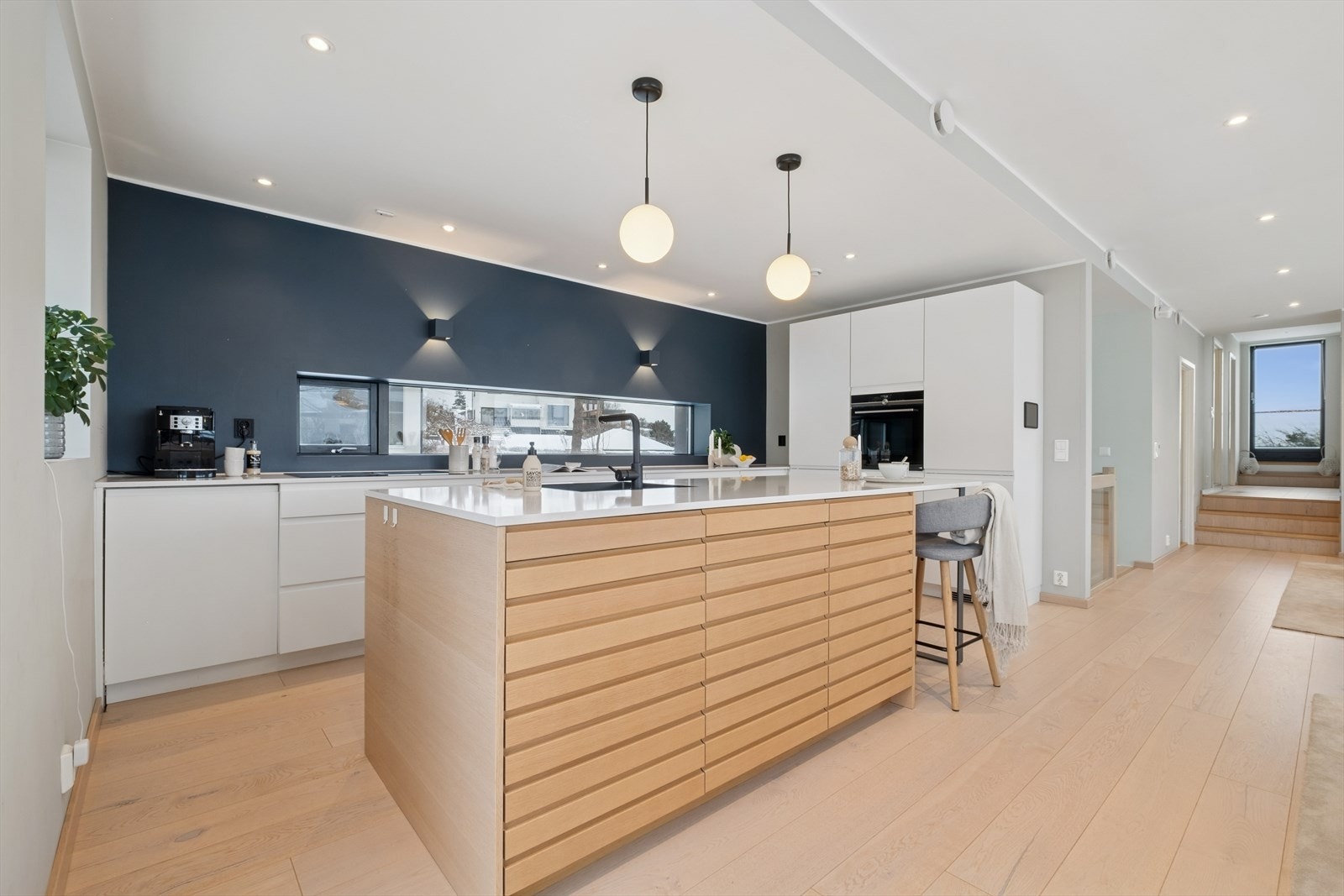 Flott innredning fra Kvik med kvartskompositt benkeplate og en nedfelt, sort kum i rustfritt stål. Galleribilde