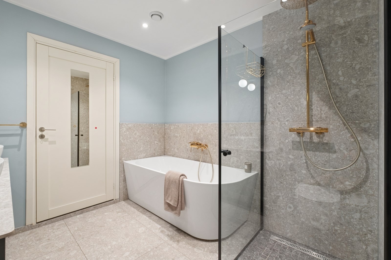 Videre har badet vegghengt toalett, flislagt dusjhjørne med glassvegger og badekar. Galleribilde