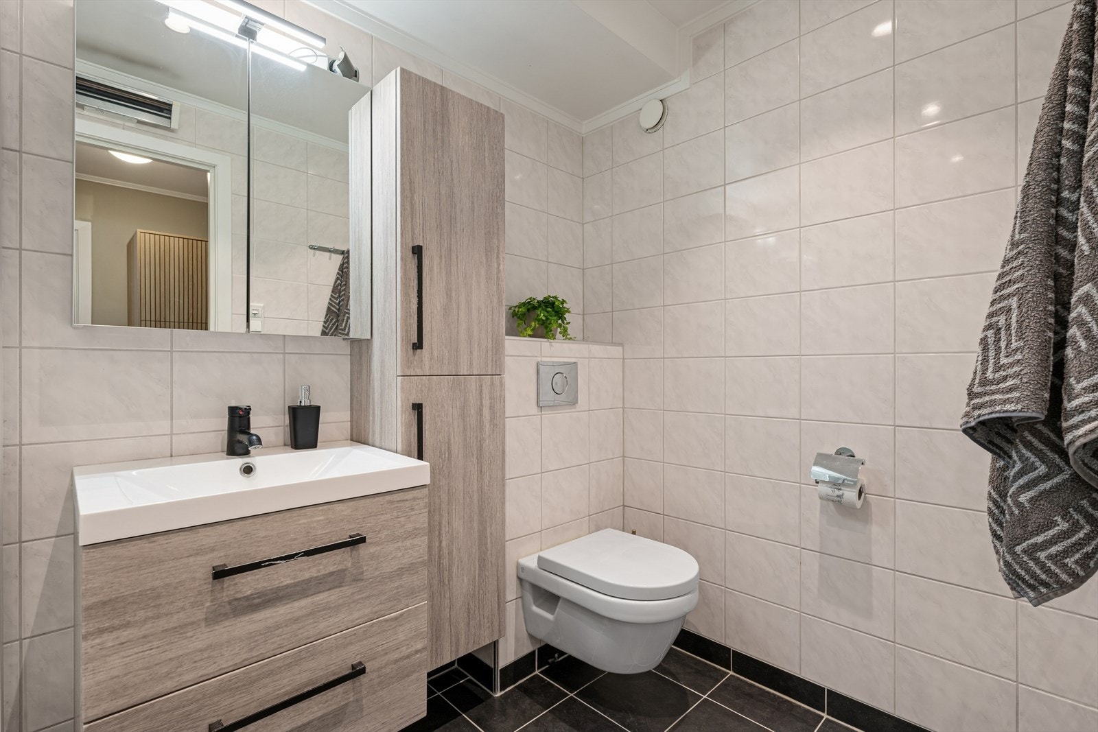 Badet ble oppgradert i 2016 og er pent innredet med lyse, sjatterte fliser på vegg og mørke fliser på gulv. Galleribilde