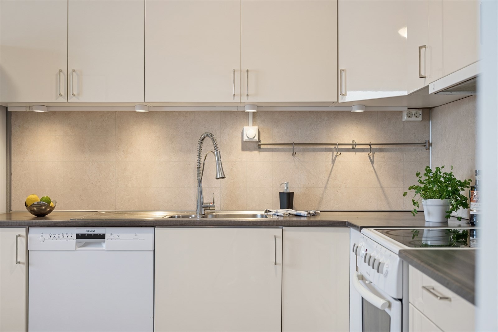 Plater bak kjøkkenbenken gjør det enkelt å holde det rent med mat- og vannsøl. Galleribilde