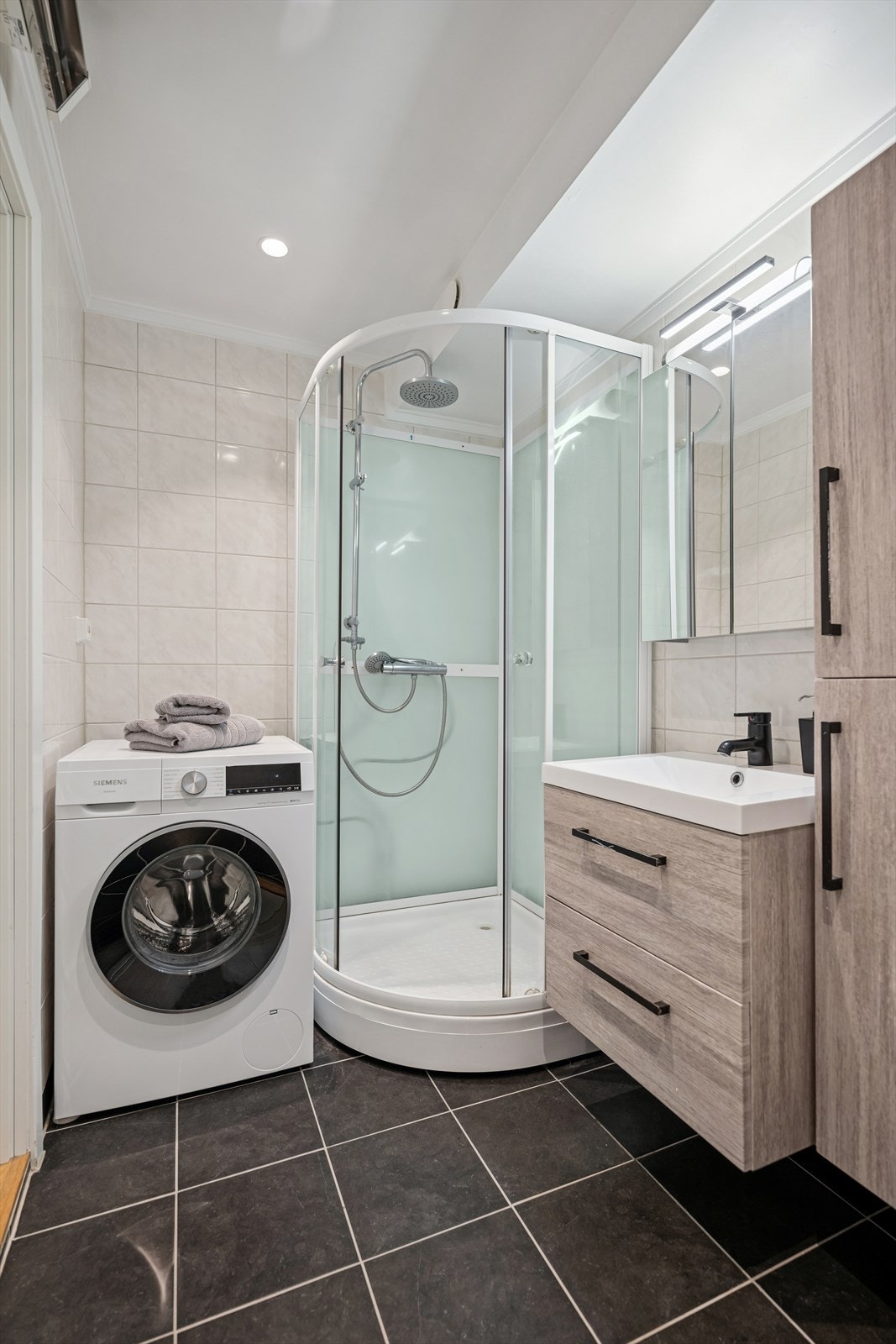 Badet er ellers utstyrt med dusjkabinett, vegghengt toalett og baderomsinnredning med god lagringsplass og nedfelt servant. Galleribilde