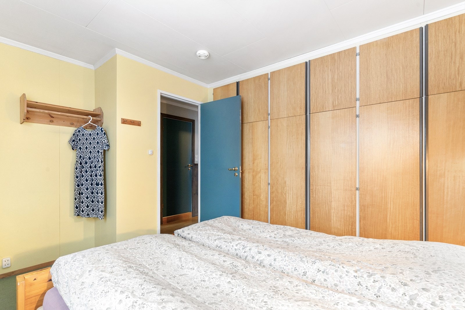 Vegg til vegg garderobe gir praktisk plassutnyttelse av rommet. Galleribilde