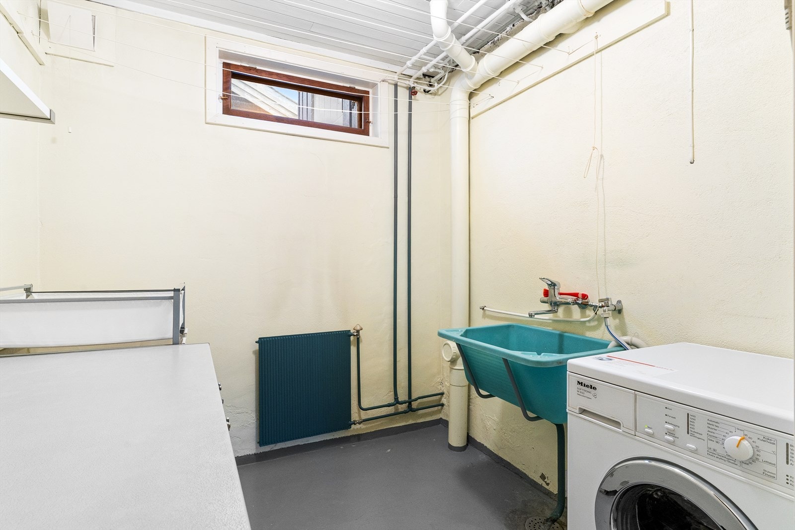 Eldre vaskerom med opplegg for vaskemaskin og skyllekum. Galleribilde