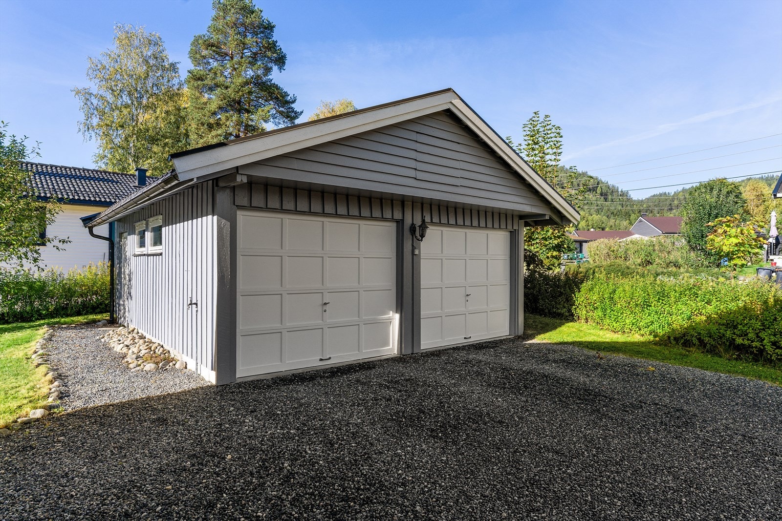 Til eiendommen hører en praktisk dobbeltgarasje, med 2 leddporter og egen sideinngang i bakkant. Galleribilde