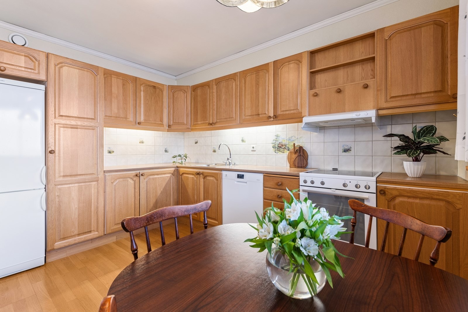 Det er belysning under overskapene og fliser på vegg over benkeplaten. Galleribilde