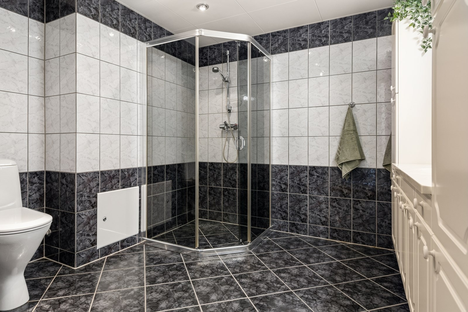 Badet har fliser på vegger og gulv, med elektriske varmekabler i gulvet. Galleribilde