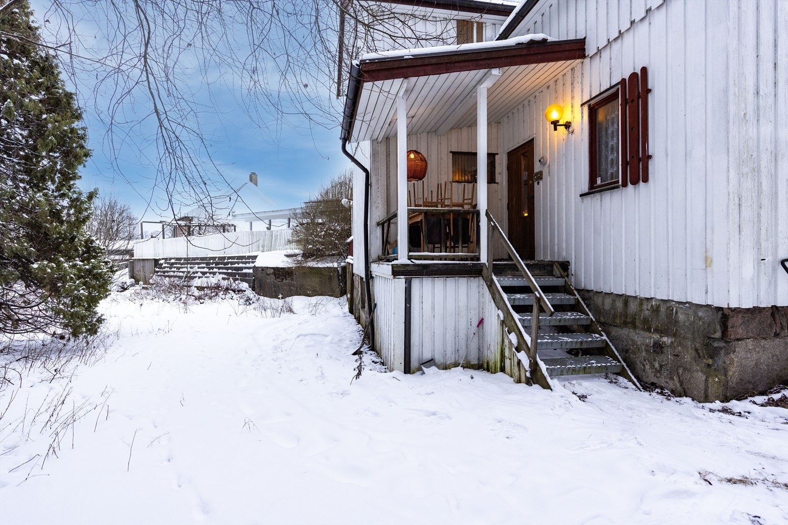 Ved inngangspartiet er det en takoverbygget balkong på ca. 5 kvm, som skjermer mot vind og vær. En trapp med solide trinn i stål leder opp til boligens inngang. Galleribilde