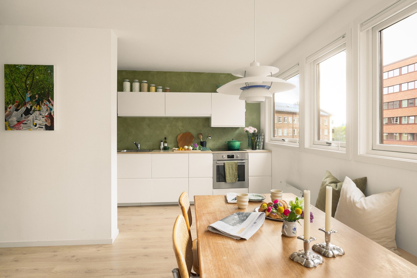 Spisebordet har sin naturlige plass i forkant av innredningen, og legger til rette for sosiale måltider hvor familie og venner kan samles, samtidig som matlagingen pågår. Galleribilde