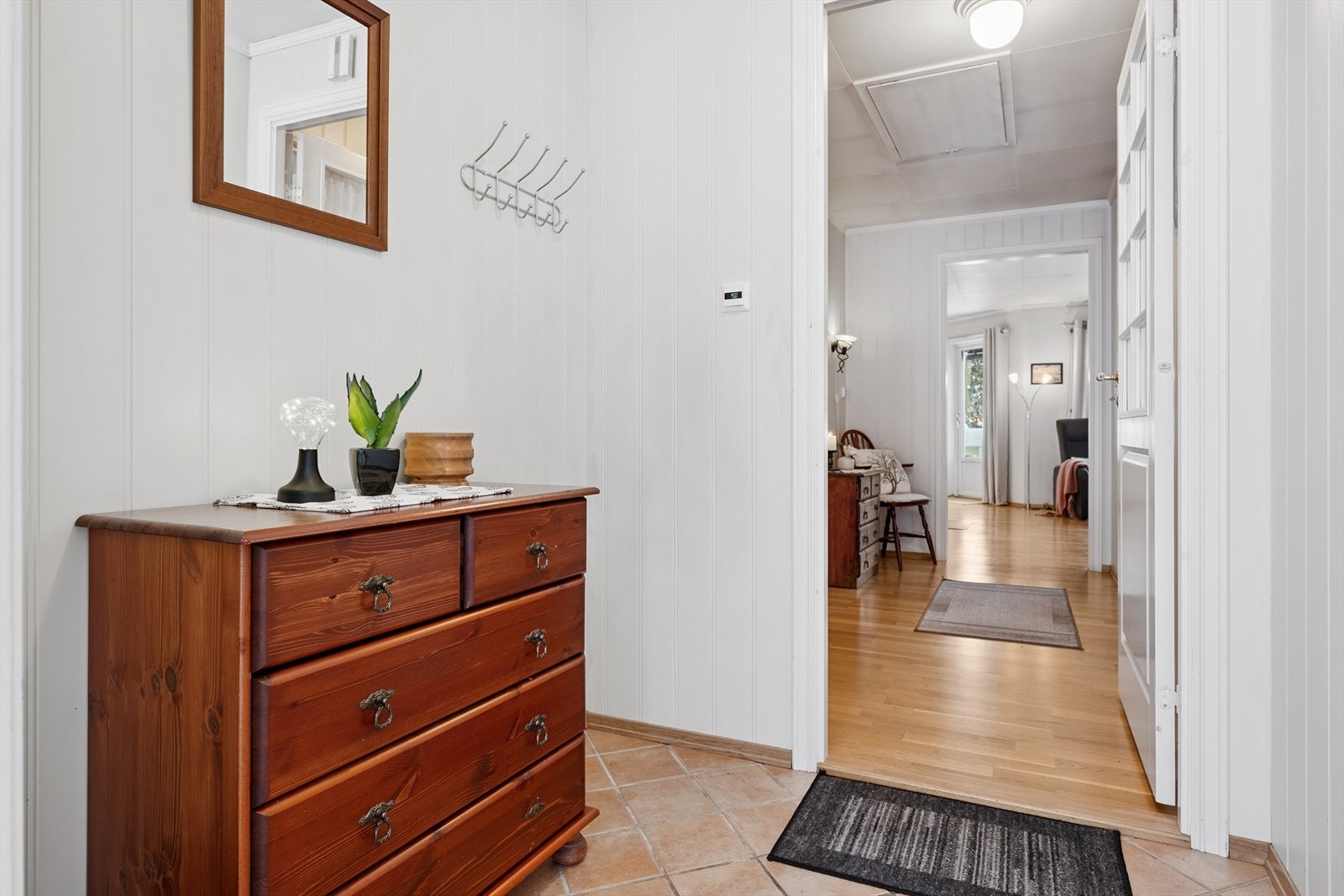 Velkommen inn i en entré med flislagt gulv og behagelig gulvvarme. Galleribilde