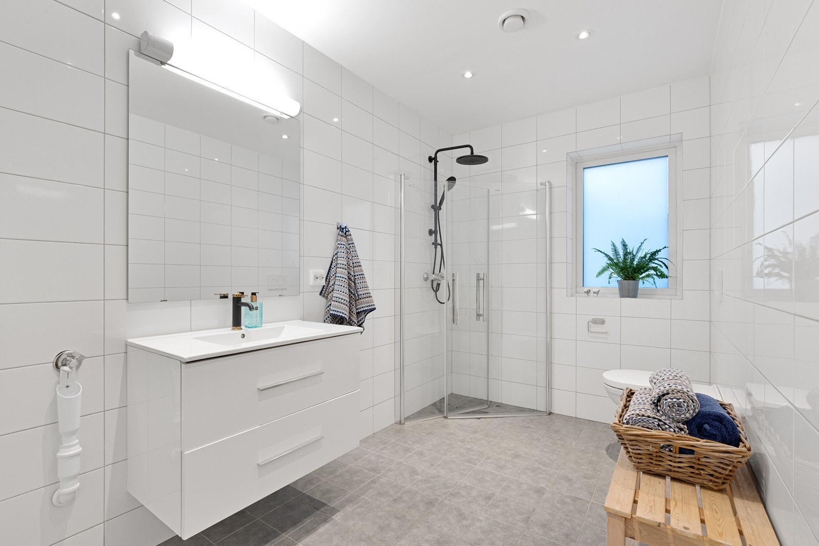 Hovedbadet er romslig og helfliset, med dusjhjørne med glassdører. Galleribilde