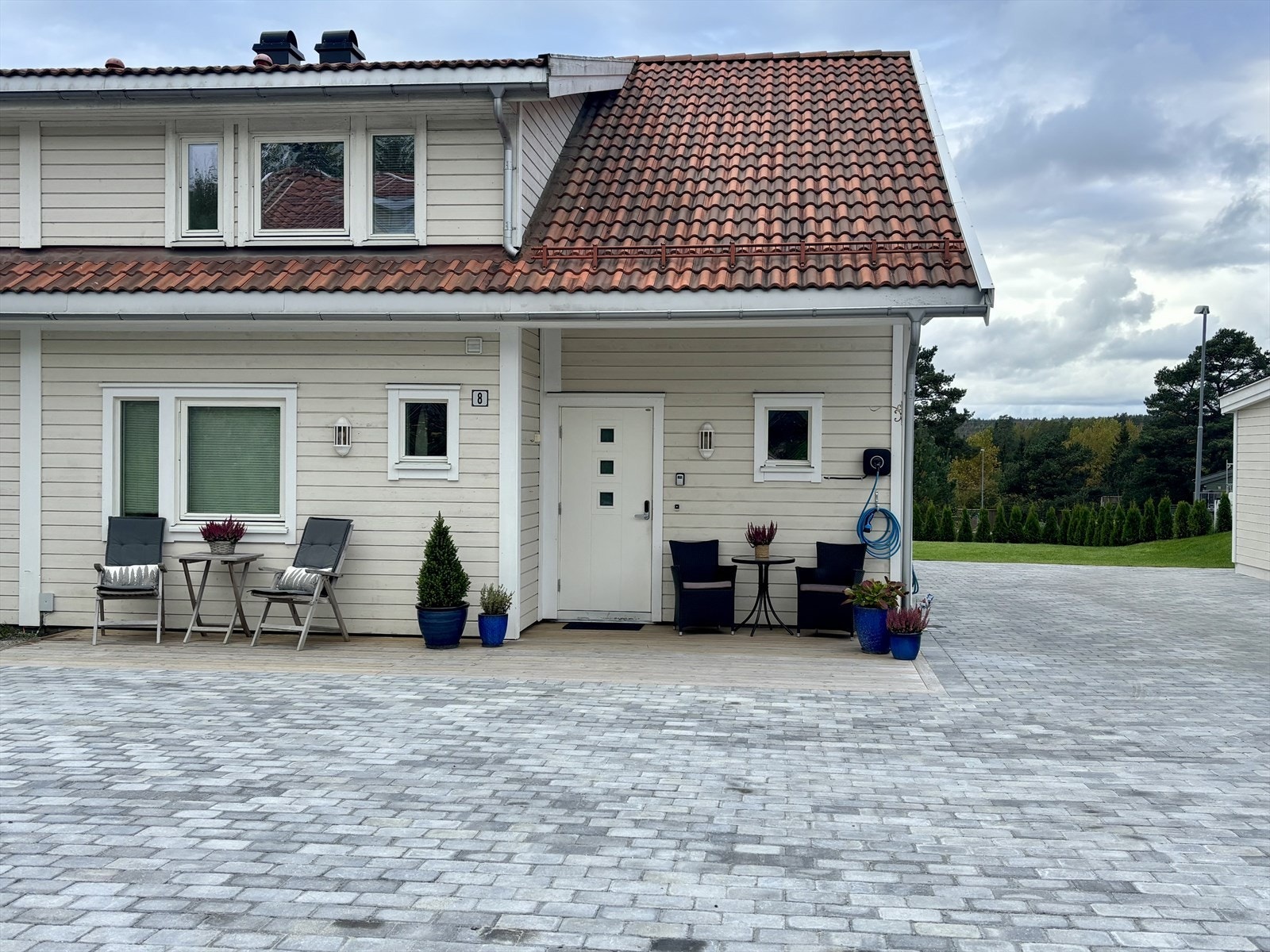 Overbygget inngangsparti med plass til en liten sittegruppe (Selgers private bilde fra sommer) Galleribilde