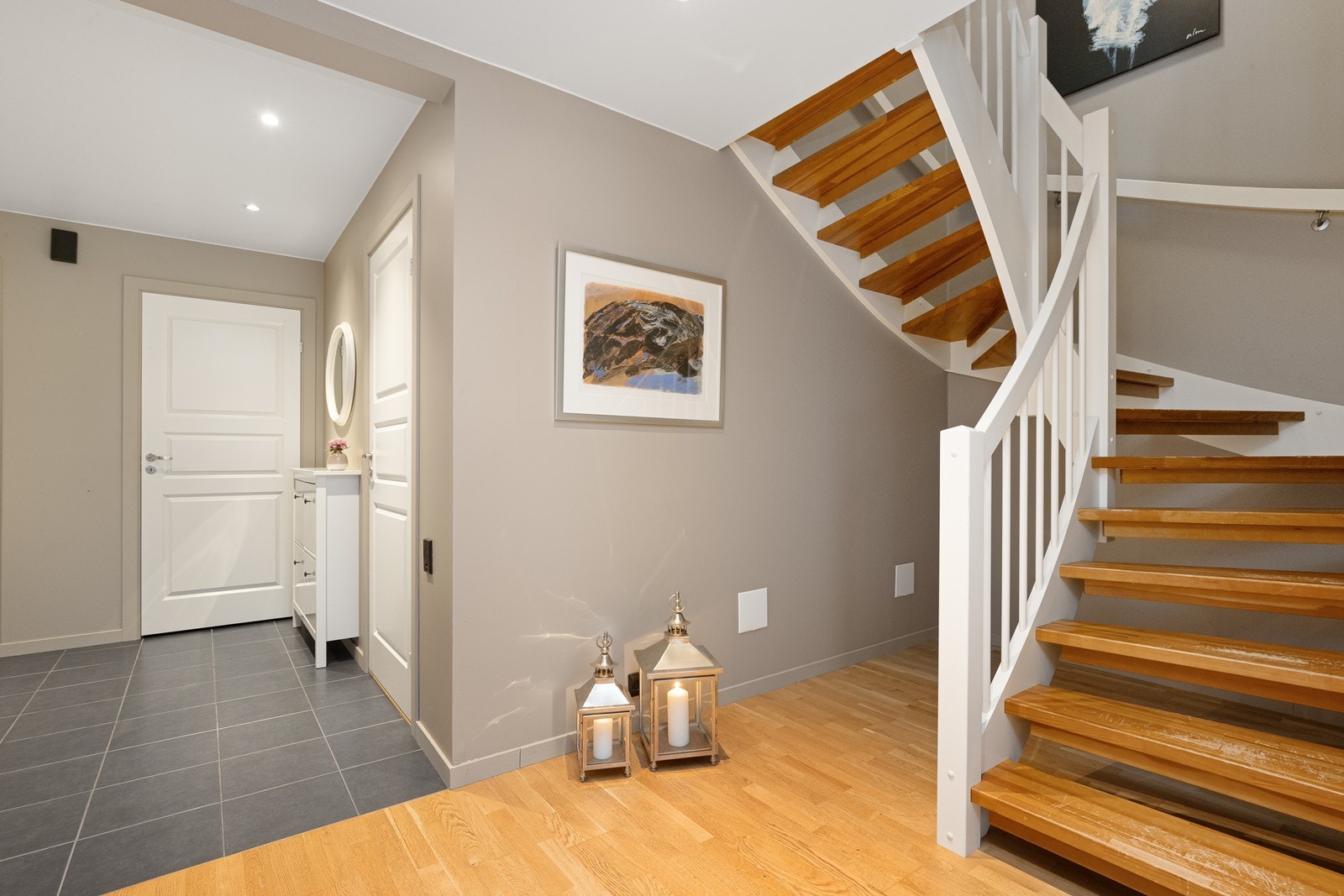 Den svingte trappen i tre og hvitt leder elegant opp til andre etasje. Galleribilde