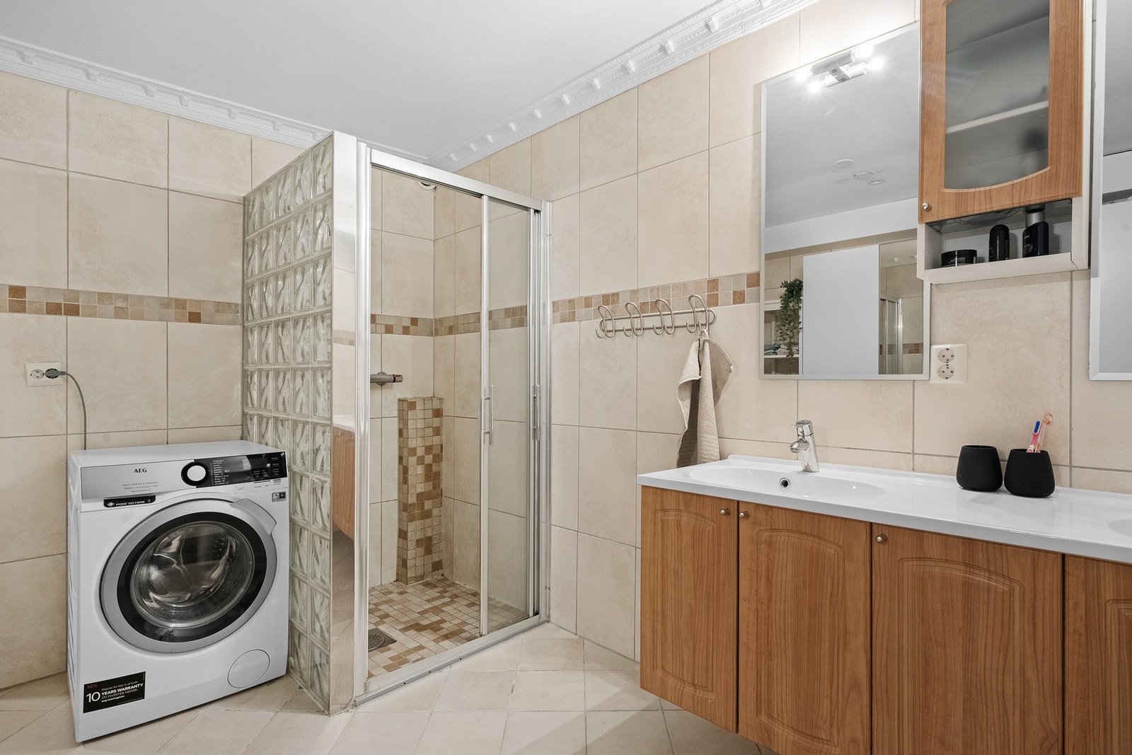 Helfliset bad med opplegg for vaskemaskin og praktiske løsninger for en funksjonell hverdag. Galleribilde