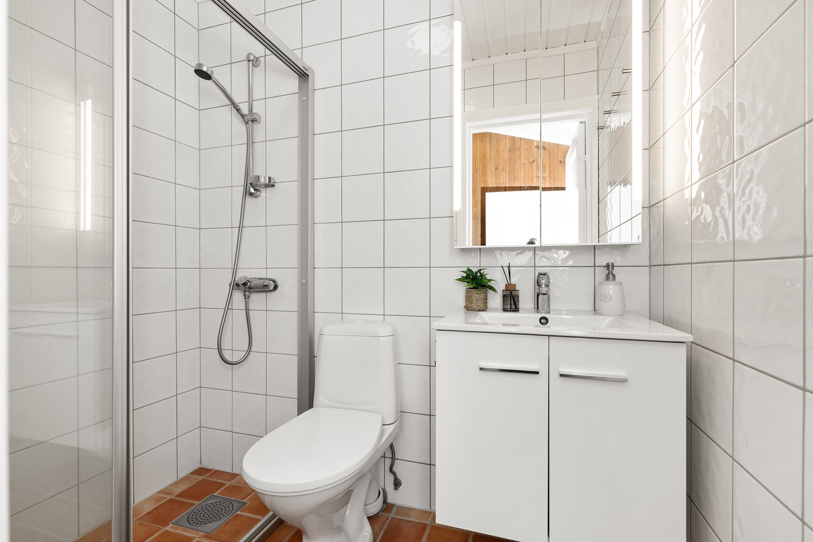 Badet har støpt gulv med varmekabler og helflisede overflater på gulv og vegg. Galleribilde